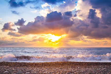 Beautiful sea landscape with a sunset. Evening purple sky with clouds over ocean. Sea surf with wavesの写真素材