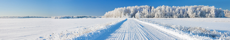 beautiful winter landscape panorama with road and forest. panoramic view of snow covered forest and fieldの写真素材