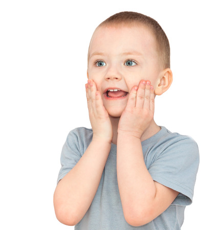 happy little  child smiles isolated on a white background. beautiful small  boy cheerful laughs. kid holds hands on headの写真素材