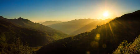 beautiful panorama landscape with sunrise over mountains. twilight sun is rising in mountains on dawn panoramic viewの写真素材