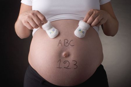 seven month pregnant belly with ABC and 123 written with  shoes