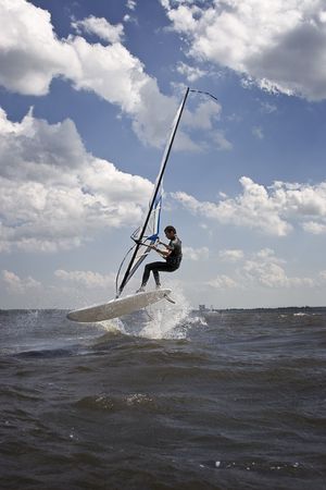 Windsurfer doing a jump trick in the waterの写真素材