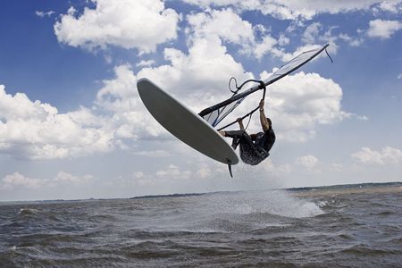Windsurfer doing a jump trick in the water and catching lots of airの写真素材