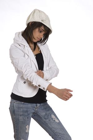 Teenage girl pulling up her sleeve wearing knitted hat and jeans with holesの写真素材