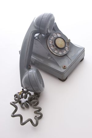 dirty vintage gray unhooked rotary phone with crack casing and expose wiredの写真素材