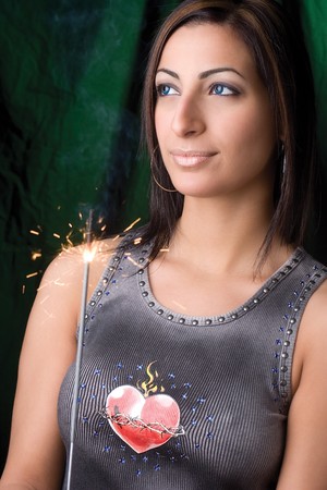Twenty something fashion model holding a burning and smoking birthday sparkler の写真素材