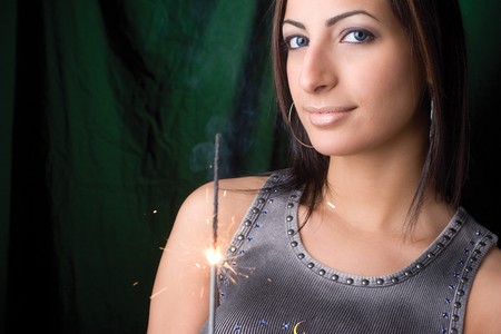 Twenty something fashion model holding a burning and smoking birthday sparklerの写真素材