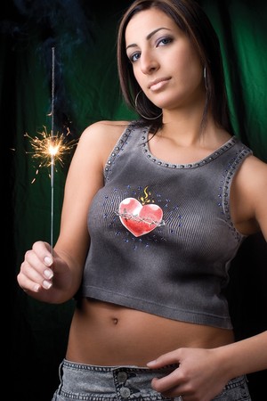 Twenty something fashion model holding a burning and smoking birthday sparklerの写真素材