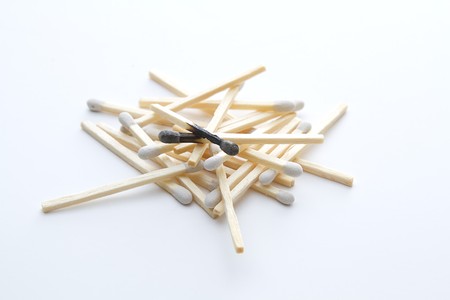 random stack of white tip matches with two burn matches to a crispの写真素材