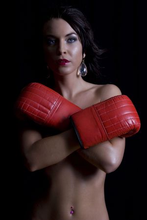 Twenty something women holding her breast with boxing gloveの写真素材
