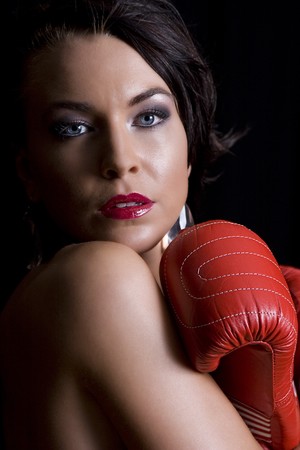 young twenty something women hiding her body with red boxing gloveの写真素材