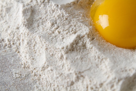egg yoke in a nest of flourの写真素材