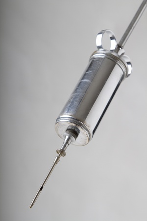 vintage vetenarian syringe against gray backgroundの写真素材