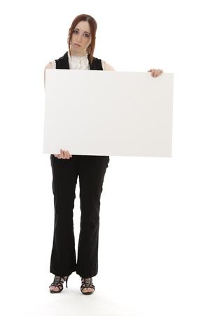 Young woman in business suit holding a white sign with a sad expression against a white backgroundの写真素材