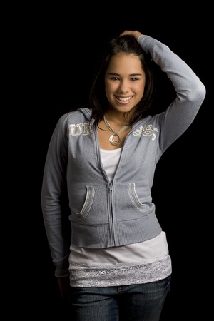 Teen girl standing against a black backgroundの写真素材