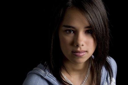 Head shot of a teen girl against a black backgroundの写真素材