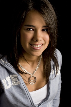 Teen girl smiling against a black backgroundの写真素材