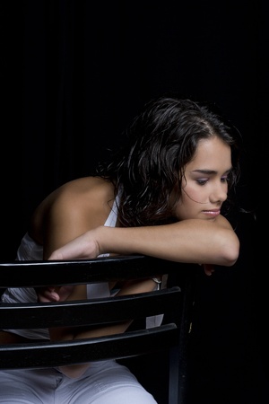 Teen girl with wet curly hair sitting on a chairの写真素材