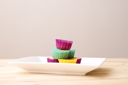 Plate of small undecorated cupcake in multicolored paper cupの写真素材