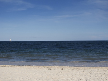 Landscape view of the atlantic ocean with a small boat on the horizoneの写真素材