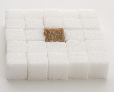 white sugar cube with one brown sugar cube place in a square shapeの写真素材