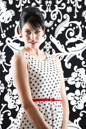 young woman in front of a black and white textured background with 60's inspired styleの写真素材