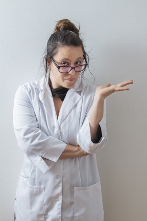 thirtie something brunette woman wearing a lab coat with glasses with a expression of reprimandの写真素材