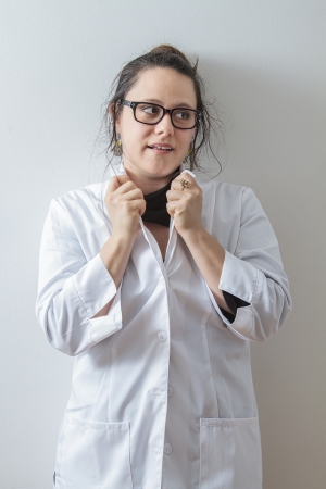 thirtie something brunette woman wearing a lab coat holding up her collarの写真素材