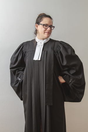 thirtie something brunette woman wearing a canadian lawyer toga with hands on her hips and a quirky smileの写真素材