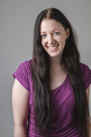 young woman with long black hair and a purple shirt with great big smileの写真素材