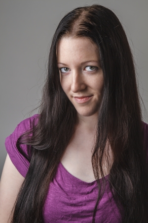 portrait of a young woman with long black hair and a purple shirtの写真素材