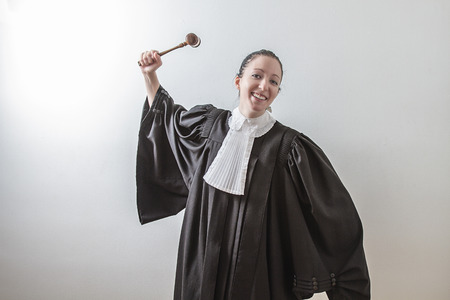 twenty something woman wearing a canadian lawyer toga with a gavel in her handの写真素材
