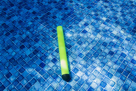 glow stick toy at the bottom of a poolの写真素材