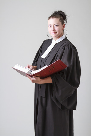 Woman lawyer holding an opened red law bookの写真素材