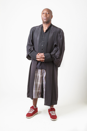 bald black man wearing a preacher toga, short and sneakerの写真素材