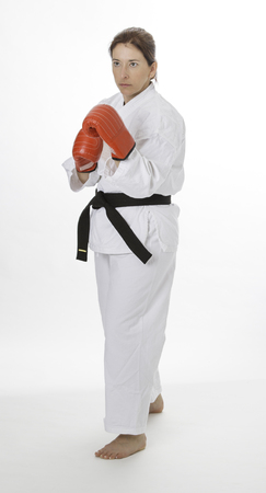 woman wearing a karate uniform and red boxing gloveの写真素材