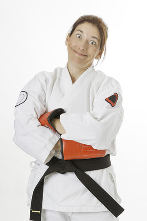 woman wearing a karate uniform and red boxing glove making a funny faceの写真素材
