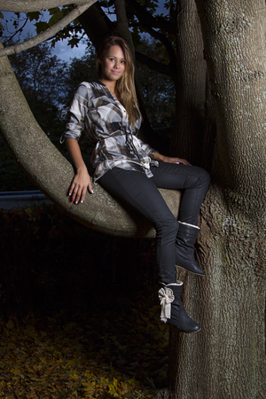 Young woman sitting on a tree branchの写真素材