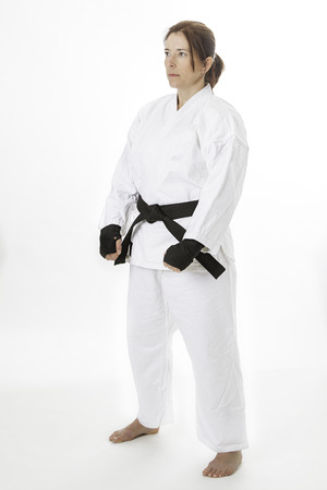 woman in her fortie, wearing black hand protec and a martial art uniform, in first stanceの写真素材