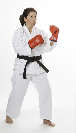 woman in her fortie, wearing red boxing gloves, thinking about her next punchの写真素材