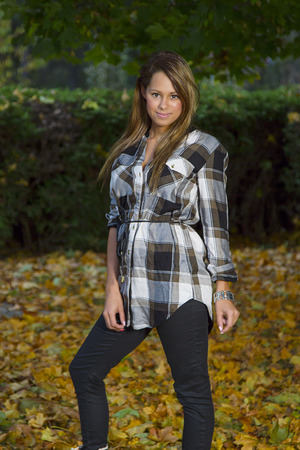 young woman standing in dead leavesの写真素材
