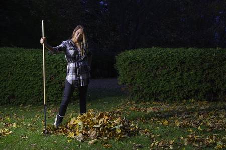 young woman in her twenties, raking leavesの写真素材