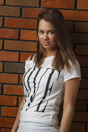 twenty something girl standing in front of a brick wallの写真素材