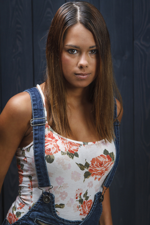 twenty something beautiful girl wearing a flowered patterned tank top and jean overhaulの写真素材