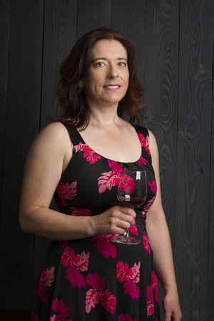 forty year old woman wearing a summer dress, holding a glass of red wineの写真素材