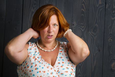 overweight woman in her forties, wearing a summer dress, adjusting her dressの写真素材
