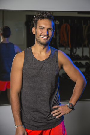 Young man wearing gym clothes in front of a mirrorの写真素材