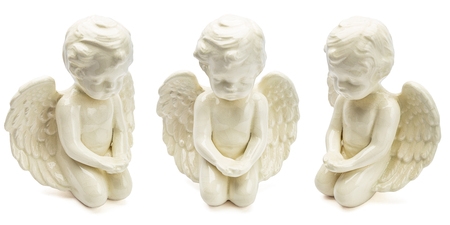 small figurine of white angel, kneeling with open wingの写真素材