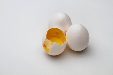 two ful egg, on egg with it's top crack open, exposed inside skin and yokeの写真素材