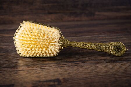 Antique hair brush against a dark wood backgroundの写真素材